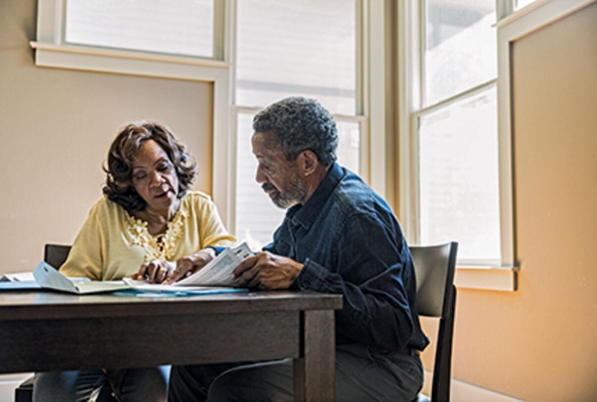 Senior couple paying bills at home